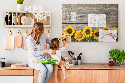 Tablero de corcho decorado con diseño de girasoles sobre fondo de tablas de madera