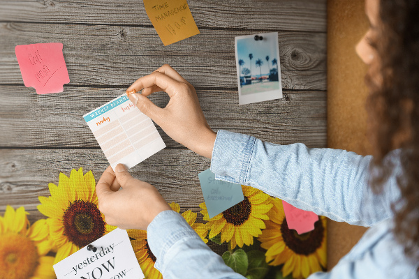 Tablero de corcho decorado con diseño de girasoles sobre fondo de tablas de madera