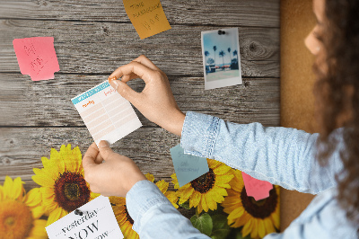 Tablero de corcho decorado con diseño de girasoles sobre fondo de tablas de madera