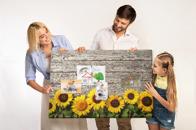 Tablero de corcho decorado con diseño de girasoles sobre fondo de tablas de madera
