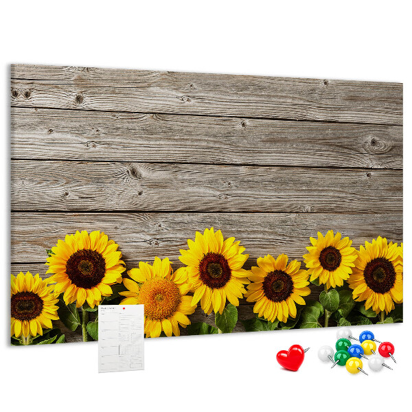 Tablero de corcho decorado con diseño de girasoles sobre fondo de tablas de madera