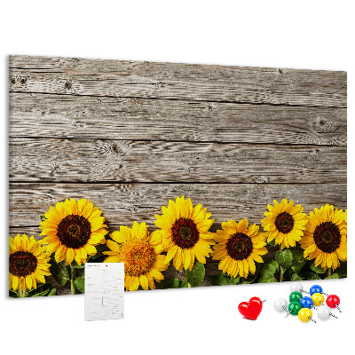 Tablero de corcho decorado con diseño de girasoles sobre fondo de tablas de madera