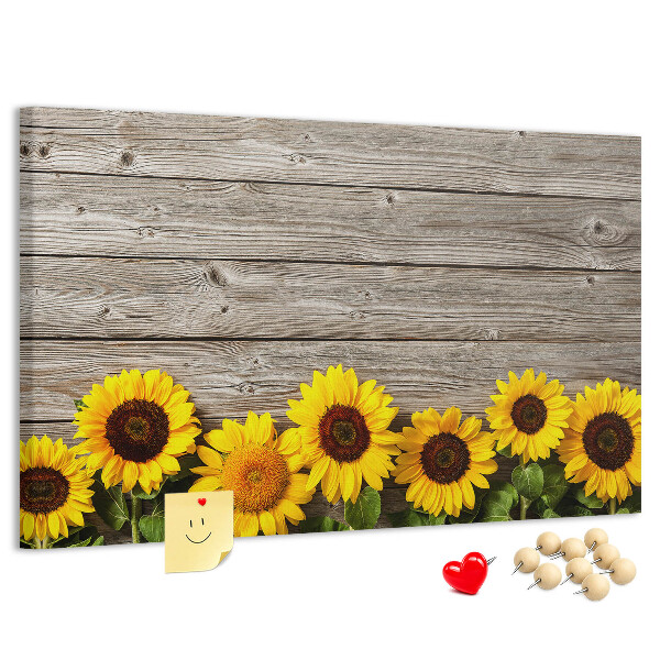 Tablero de corcho decorado con diseño de girasoles sobre fondo de tablas de madera