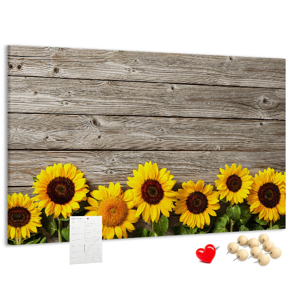 Tablero de corcho decorado con diseño de girasoles sobre fondo de tablas de madera