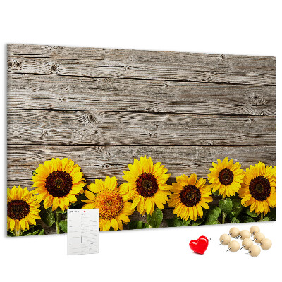 Tablero de corcho decorado con diseño de girasoles sobre fondo de tablas de madera