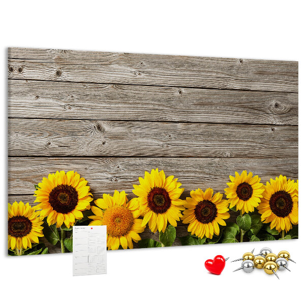 Tablero de corcho decorado con diseño de girasoles sobre fondo de tablas de madera