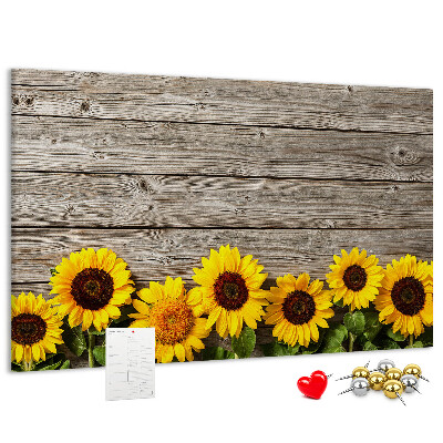 Tablero de corcho decorado con diseño de girasoles sobre fondo de tablas de madera