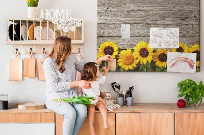 Tablero de corcho decorado con diseño de girasoles sobre fondo de tablas de madera