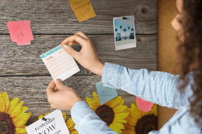 Tablero de corcho decorado con diseño de girasoles sobre fondo de tablas de madera