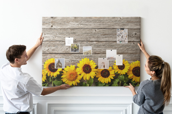 Tablero de corcho decorado con diseño de girasoles sobre fondo de tablas de madera