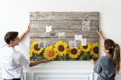 Tablero de corcho decorado con diseño de girasoles sobre fondo de tablas de madera