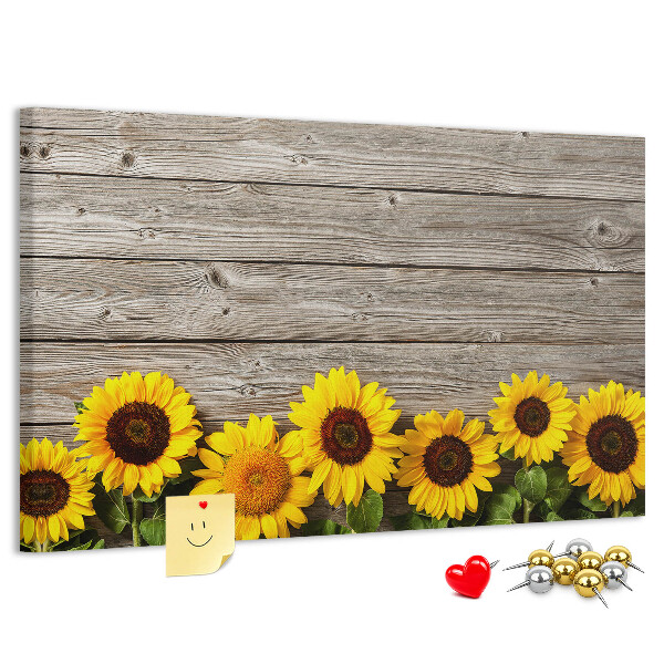 Tablero de corcho decorado con diseño de girasoles sobre fondo de tablas de madera