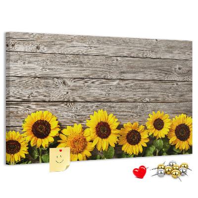 Tablero de corcho decorado con diseño de girasoles sobre fondo de tablas de madera