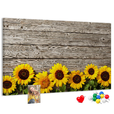 Tablero de corcho decorado con diseño de girasoles sobre fondo de tablas de madera
