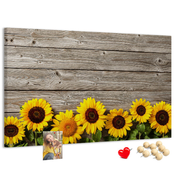 Tablero de corcho decorado con diseño de girasoles sobre fondo de tablas de madera