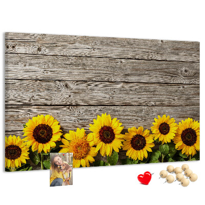 Tablero de corcho decorado con diseño de girasoles sobre fondo de tablas de madera