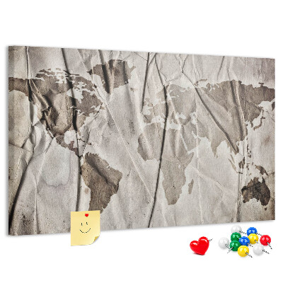Tablero de corcho decorado Un mapamundi dañado sobre un fondo de papel.