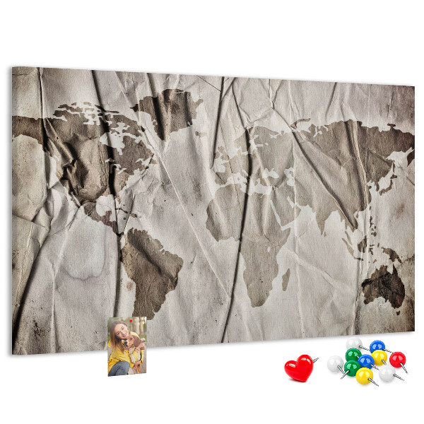Tablero de corcho decorado Un mapamundi dañado sobre un fondo de papel.
