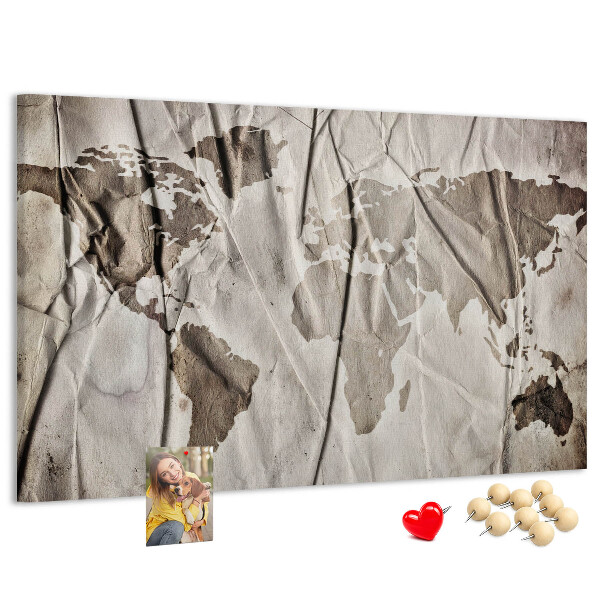 Tablero de corcho decorado Un mapamundi dañado sobre un fondo de papel.