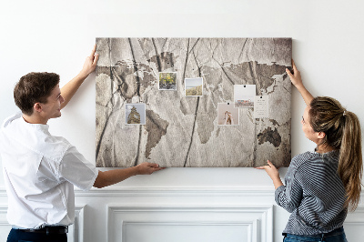 Tablero de corcho decorado Un mapamundi dañado sobre un fondo de papel.