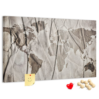 Tablero de corcho decorado Un mapamundi dañado sobre un fondo de papel.