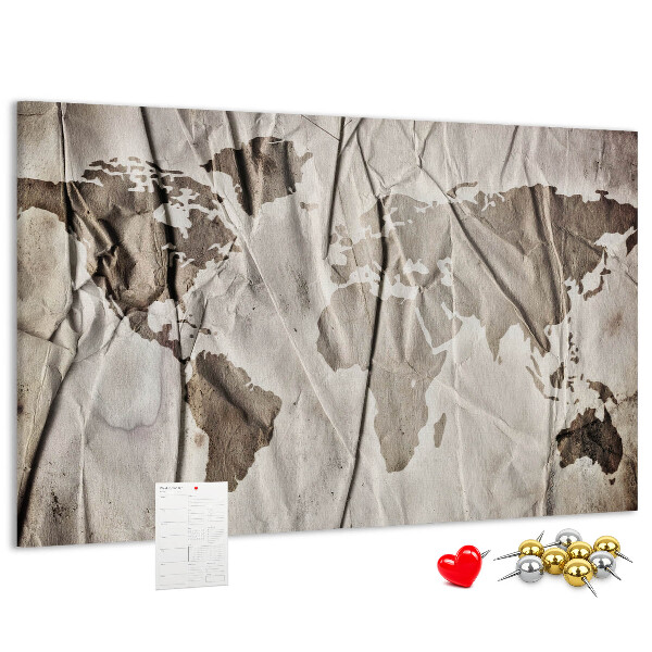 Tablero de corcho decorado Un mapamundi dañado sobre un fondo de papel.