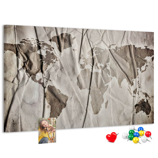 Tablero de corcho decorado Un mapamundi dañado sobre un fondo de papel.