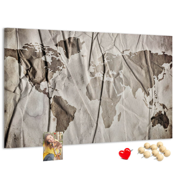 Tablero de corcho decorado Un mapamundi dañado sobre un fondo de papel.