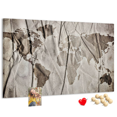 Tablero de corcho decorado Un mapamundi dañado sobre un fondo de papel.
