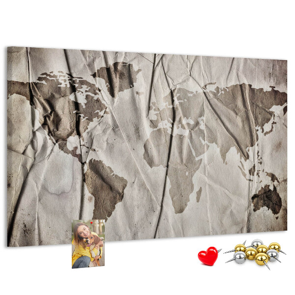 Tablero de corcho decorado Un mapamundi dañado sobre un fondo de papel.