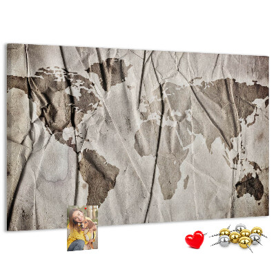 Tablero de corcho decorado Un mapamundi dañado sobre un fondo de papel.