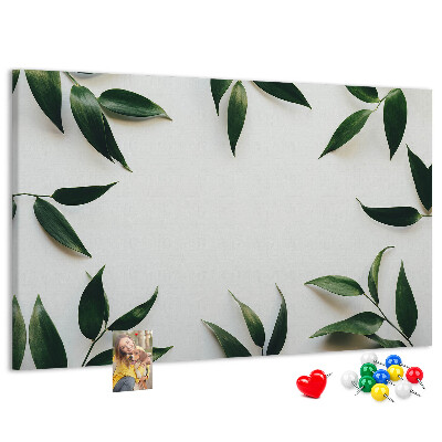 Pizarra de corcho con hojas en una delicada y minimalista composición