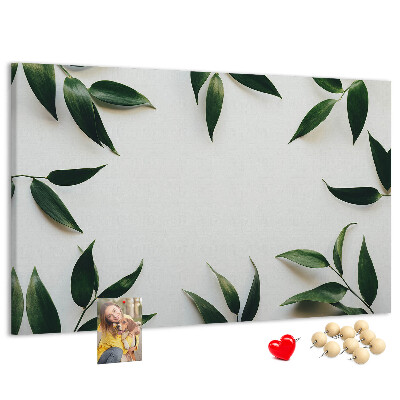 Pizarra de corcho con hojas en una delicada y minimalista composición