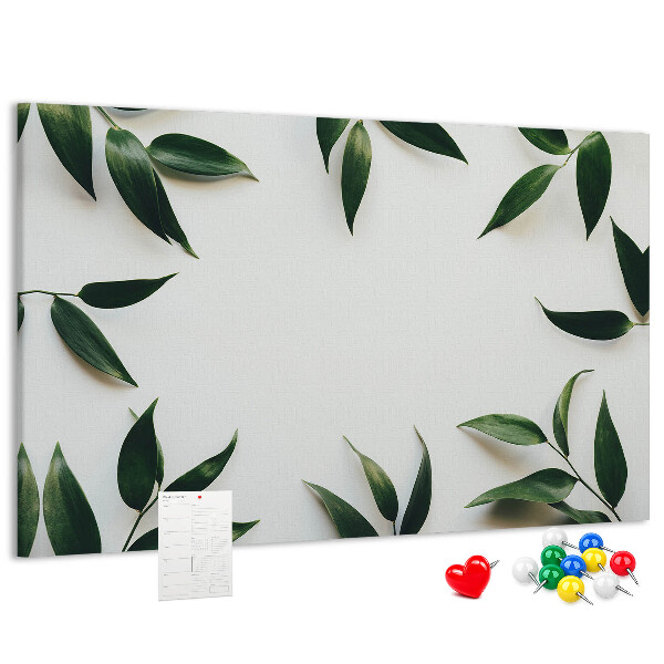 Pizarra de corcho con hojas en una delicada y minimalista composición