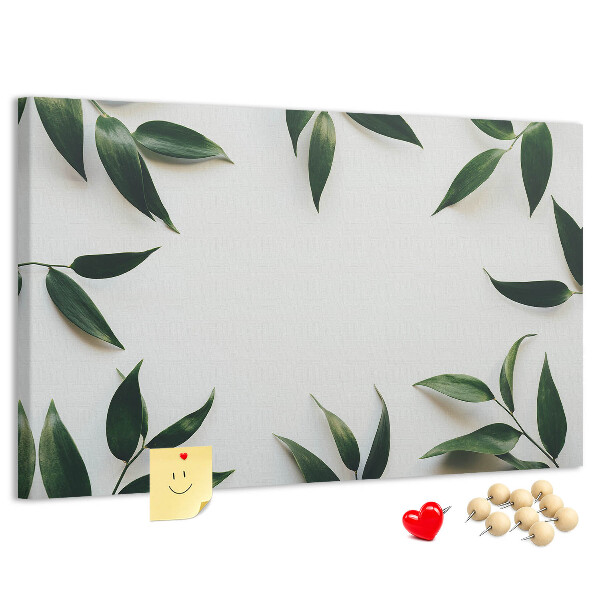Pizarra de corcho con hojas en una delicada y minimalista composición
