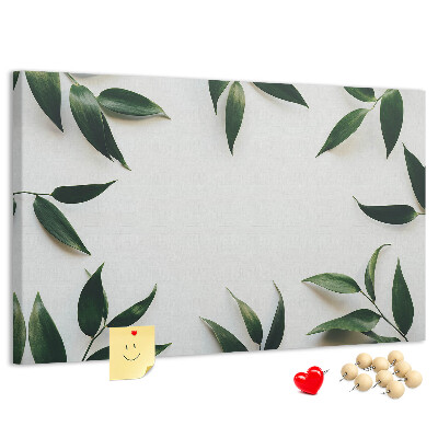 Pizarra de corcho con hojas en una delicada y minimalista composición