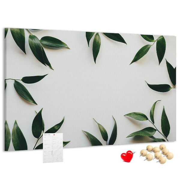 Pizarra de corcho con hojas en una delicada y minimalista composición