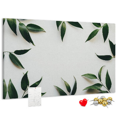 Pizarra de corcho con hojas en una delicada y minimalista composición