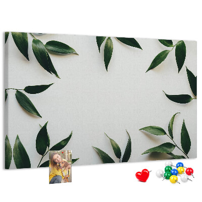 Pizarra de corcho con hojas en una delicada y minimalista composición