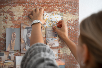 Tablero de corcho decorado Un mapamundi contra una pared de ladrillos