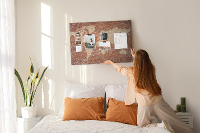 Tablero de corcho decorado Un mapamundi contra una pared de ladrillos