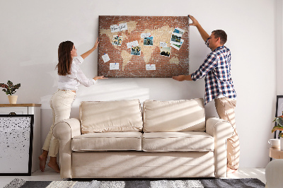 Tablero de corcho decorado Un mapamundi contra una pared de ladrillos
