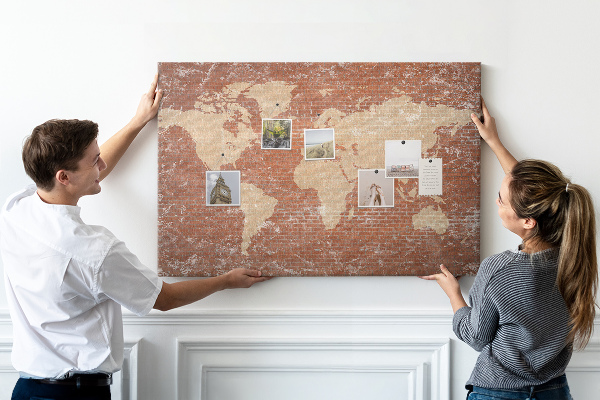 Tablero de corcho decorado Un mapamundi contra una pared de ladrillos