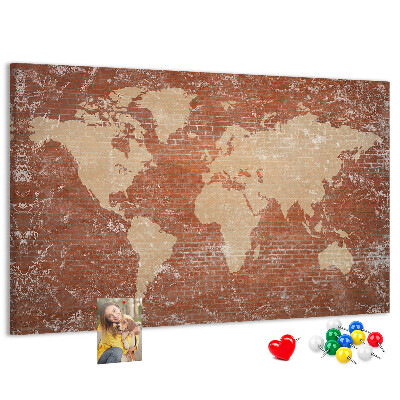 Tablero de corcho decorado Un mapamundi contra una pared de ladrillos