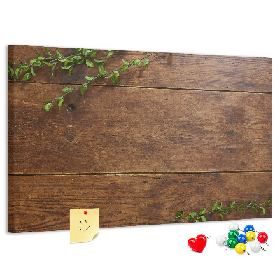 Pizarra de corcho con marco de madera natural y decoración de ramas verdes