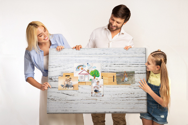 Tablero de corcho decorado con diseño de recuerdos familiares sobre fondo de madera