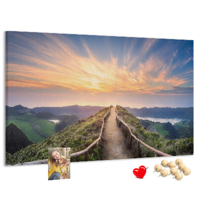 Tablero de corcho decorado con diseño de un sendero pintoresco en las montañas al atardecer