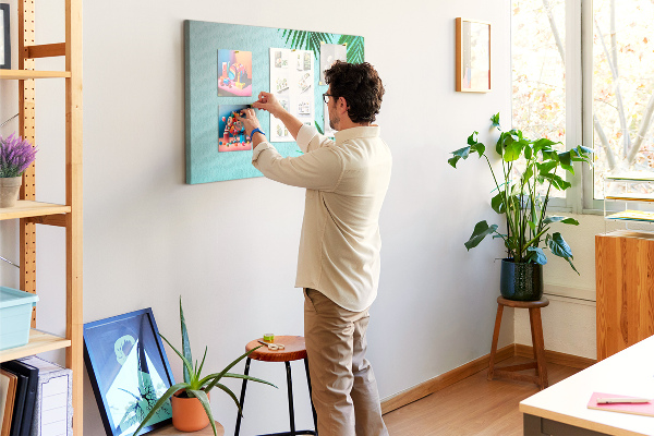 Tablero de corcho decorado con diseño de hojas tropicales sobre fondo azul