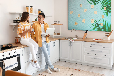 Tablero de corcho decorado con diseño de hojas tropicales sobre fondo azul