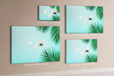 Tablero de corcho decorado con diseño de hojas tropicales sobre fondo azul